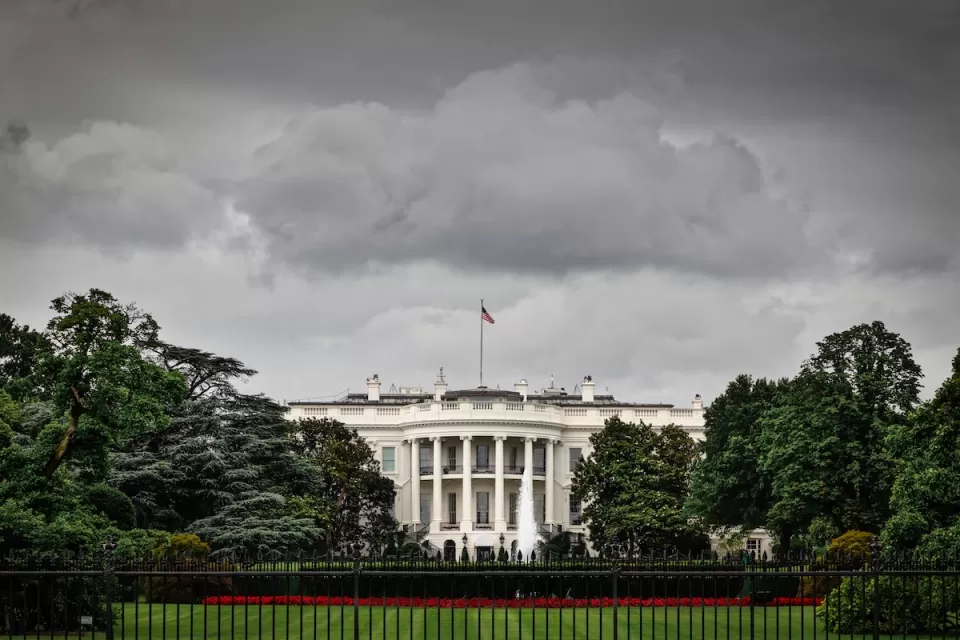 Front of White House with stormy sky above.